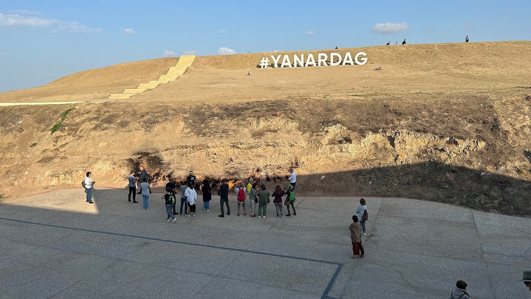 Yanardağ qoruğunda alovlu yamacın qarşısındakı meydança və təpədəki "#YANARDAG" yazısı