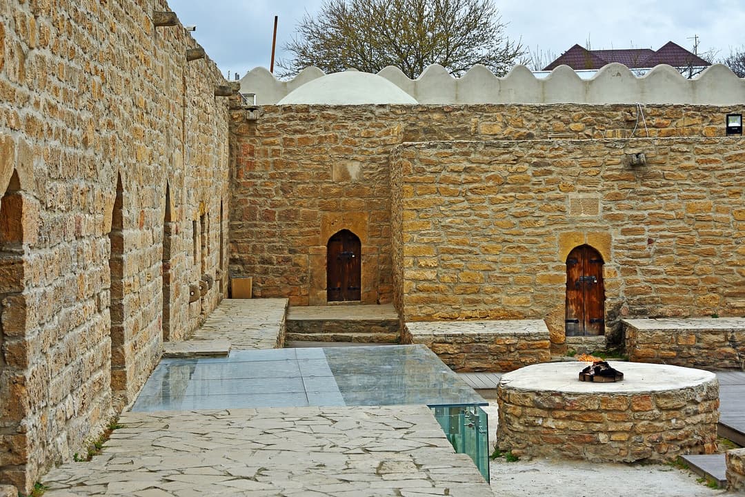Atəşgahın həyəti: zəvvar hücrələri və içində alov yanan daş quyu